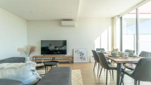 a living room with a table and chairs and a tv at Central Canterbury Charm Sky View Free Parking in Sydney