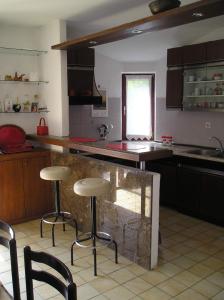 una cocina con 2 taburetes y una barra en Pine Wood Oasis Apartments, en Bol