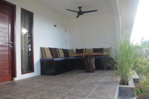 a living room with a couch and a ceiling fan at AMIGOS BUNGALOWS GILI MENO in Gili Meno