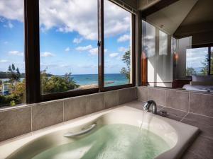 bañera con vistas al océano en La Casa Panacea Okinawa Resort en Onna