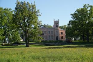 a large white house with a tower on top at Holiday Apartment in Alūksne