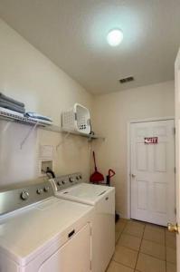 Una cocina blanca con fregadero y estufa. en Family Disney Home, Pool, Spa, in Gated Resort -126, en Orlando