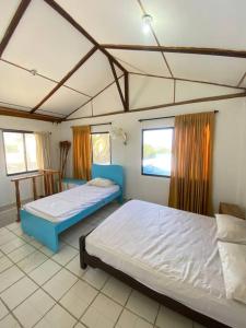 een slaapkamer met 2 bedden en 2 ramen bij Cabaña con piscina y Cerca al mar VILLA CONEJO in Juan de Acosta
