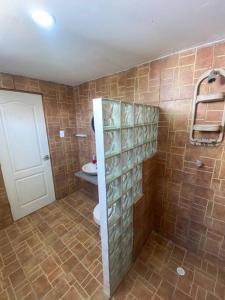 een badkamer met een toilet en een betegelde muur bij Cabaña con piscina y Cerca al mar VILLA CONEJO in Juan de Acosta