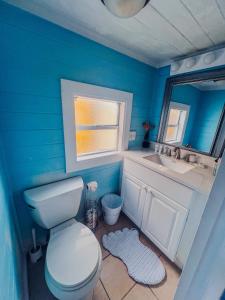 Baño azul con aseo y lavamanos en Playa Esmeralda Studios en Bradenton Beach