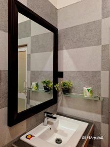a bathroom sink with a large mirror above it at Ella Odyssey Inn in Ella