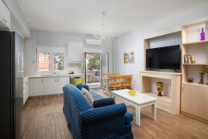 a living room with a blue couch and a table at Walk 2 the Beach; Ammoudara APTs in Ayía Marína