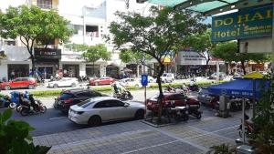 un grupo de motocicletas y coches estacionados en una calle de la ciudad en Do Hai Hotel, en Da Nang