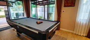 a pool table in a living room with afits at Baan Natcha Villa in Pattaya Central