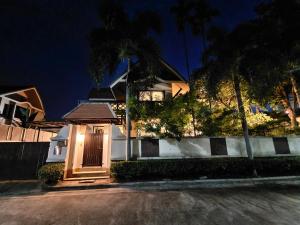 a house with a wooden door in front of a street at Baan Natcha Villa in Pattaya Central