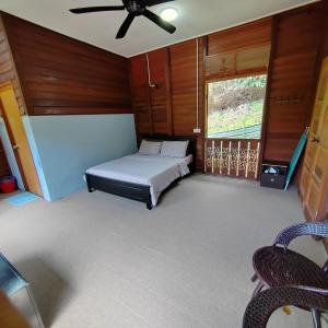 a bedroom with a bed and a ceiling fan at D'Bukit Forest in Pedas