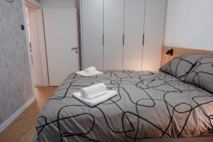 a bedroom with a bed with two towels on it at Apartment Exclusive - Self check In in Osijek