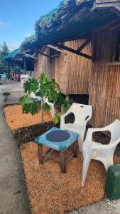 eine Gruppe weißer Stühle und ein Tisch vor einem Gebäude in der Unterkunft Nirvana Bamboo & Dive resort in Moalboal