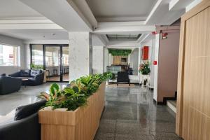 eine Bürolobby mit Sofas und Pflanzen in der Unterkunft Station 203 Hotel in Bangkok