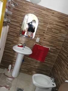 een badkamer met een wastafel, een toilet en een spiegel bij Cata 1 de la playa 2 del centro in Parque del Plata