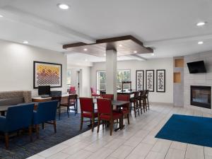 a dining room with tables and chairs and a fireplace at Holiday Inn Express Fort Bragg, an IHG Hotel in Fort Bragg