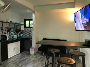 um quarto com uma mesa e bancos e uma televisão em Private Lodge Beachside Samui Lamai em Lamai