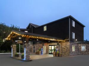 Una gran casa negra con luces encendidas. en Holiday Inn Express Fort Bragg, an IHG Hotel, en Fort Bragg