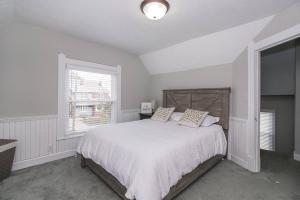 a white bedroom with a large bed and a window at Lakeside Home in Lorain in Lorain
