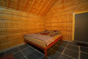 ハンピにあるMurali Guesthouse Hampiの木製の部屋にベッド付きの小さなベッドルーム1室