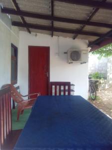 Habitación con mesa azul y puerta roja en Meera Homestay, en Anuradhapura
