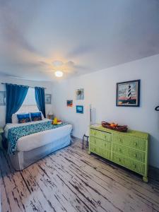 a bedroom with a bed and a dresser in it at Playa Esmeralda One Bedroom Cottages in Bradenton Beach