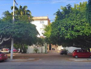 a street with cars parked in front of a building at Departamento Familiar Escorpións in Tuxtla Gutiérrez