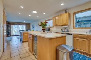 a large kitchen with a island with a vase of flowers on it at Riverfront Gem, Spa, Games, BBQ, Pet-Friendly! in Bullhead City