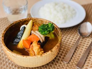 a bowl of soup with vegetables and rice on a table at Tmark City Hotel Sapporo Odori in Sapporo
