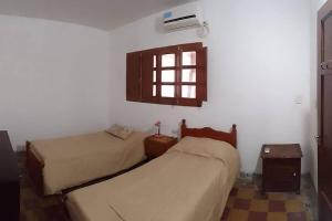 a bedroom with two beds and a window at Alquiler de casa por día. in Santiago del Estero
