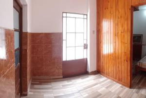 a room with a large window and a wooden door at Alquiler de casa por día. in Santiago del Estero