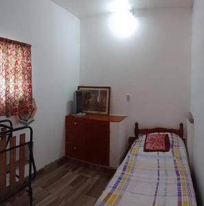 a bedroom with a bed and a tv on a dresser at Alquiler de casa por día. in Santiago del Estero