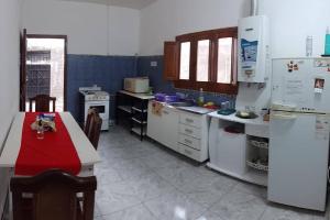 a kitchen with white appliances and a red table in it at Alquiler de casa por día. in Santiago del Estero