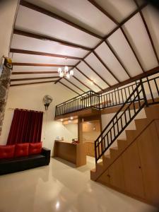 uma sala de estar com uma escada e um sofá vermelho em BERYL HOMESTAY em Tarutung