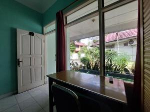 una sala da pranzo con una grande finestra e un tavolo di Grand Syariah Guest House Humanitas a Pematangsiantar