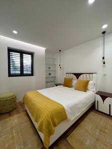 ein Schlafzimmer mit einem großen Bett und einer gelben Decke in der Unterkunft The Convo Porto Apartments in Porto