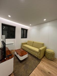 ein Wohnzimmer mit einem Sofa und einem TV in der Unterkunft The Convo Porto Apartments in Porto