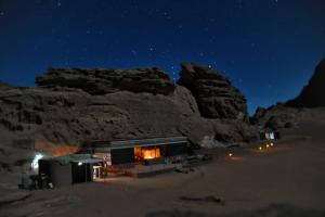 a cabin in the desert at night at um sabatah Camp in Wadi Rum
