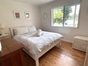 a bedroom with a large bed with a window at Barefoot Bungalow in Tomakin