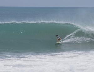 a person riding a wave on a surfboard in the ocean at Posada Mexico in Zipolite