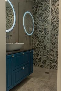 ein Badezimmer mit einem blauen Waschbecken und 2 Spiegeln in der Unterkunft The Convo Porto Apartments in Porto