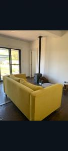 a yellow couch in a living room with a fireplace at Conteiner en Comdoro Py 