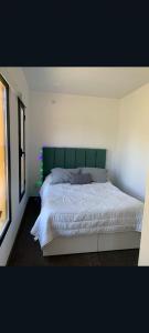 a bedroom with a large bed with a green headboard at Conteiner en Comdoro Py 