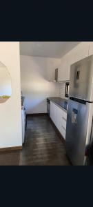 a kitchen with a stainless steel refrigerator and cabinets at Conteiner en Comdoro Py 