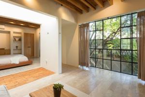 a bedroom with a bed and a large window at Jacaranda House in San Miguel de Allende