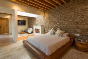 a bedroom with a brick wall and a bed at Jacaranda House in San Miguel de Allende