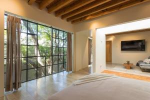 a bedroom with a large window and a large bed at Jacaranda House in San Miguel de Allende
