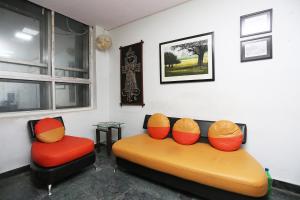 uma sala de estar com um sofá e duas cadeiras em OYO The Stay em Ballygunge