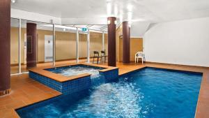 a swimming pool in a hotel room with a large swimming pool at Beachfront Bliss - shared indoor pool & spa in Cowes
