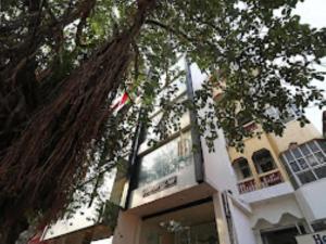 ein Gebäude mit einem Baum davor in der Unterkunft Hotel Pandav,Pachmarhi in Pachmarhi